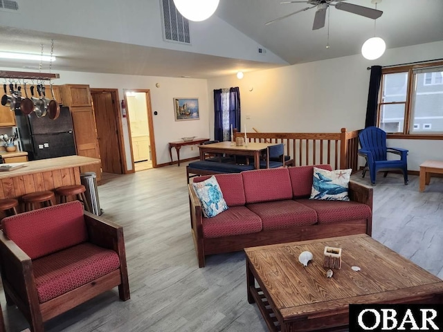 living area with light wood-type flooring, vaulted ceiling, visible vents, and ceiling fan