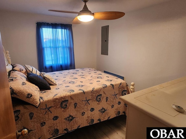 bedroom featuring electric panel, a ceiling fan, and wood finished floors
