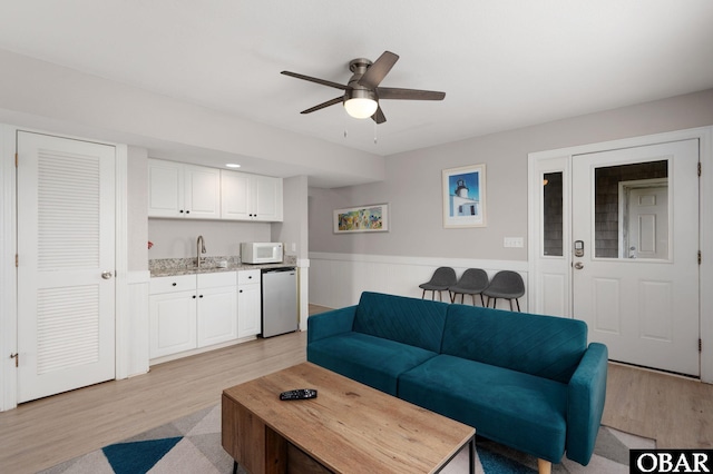 57241 Summerplace Dr Lot 28, Hatteras, NC 27943 - living room with wet bar, light wood finished floors, a ceiling fan, and wainscoting