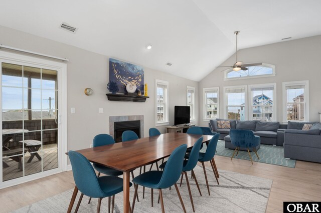 57241 Summerplace Dr Lot 28, Hatteras, NC 27943 - dining room with a tiled fireplace, a ceiling fan, light wood-type flooring, and lofted ceiling