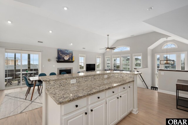 57241 Summerplace Dr Lot 28, Hatteras, NC 27943 - kitchen featuring light wood-style flooring, light stone countertops, a center island, ceiling fan, and a fireplace