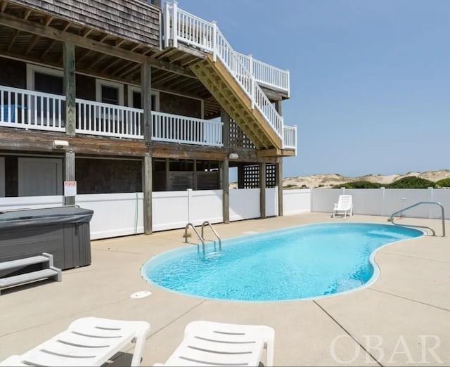 view of pool with a fenced in pool, a hot tub, a patio area, fence, and stairs