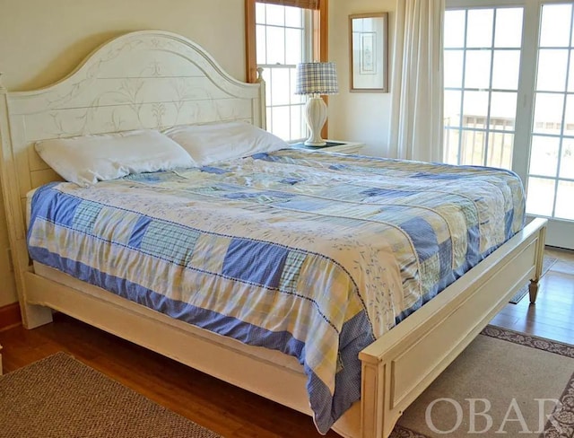 bedroom with multiple windows and wood finished floors