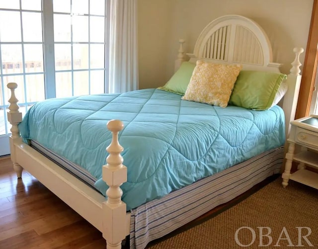 bedroom with multiple windows and wood finished floors