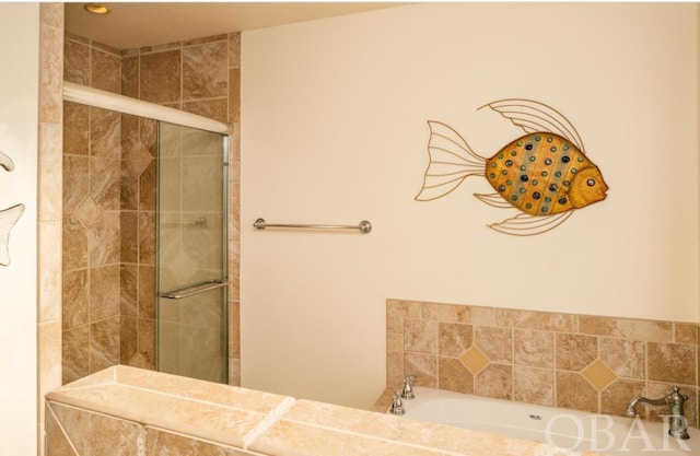 bathroom featuring a garden tub and tiled shower