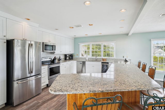 135 Ships Watch Dr Lot 32, Duck, NC 27949 - kitchen featuring appliances with stainless steel finishes, a peninsula, a breakfast bar area, plenty of natural light, and recessed lighting