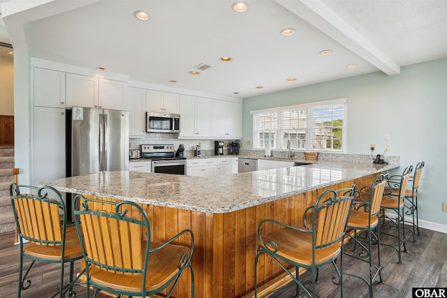135 Ships Watch Dr Lot 32, Duck, NC 27949 - kitchen featuring stainless steel appliances, dark wood-style floors, light stone counters, white cabinets, and tasteful backsplash