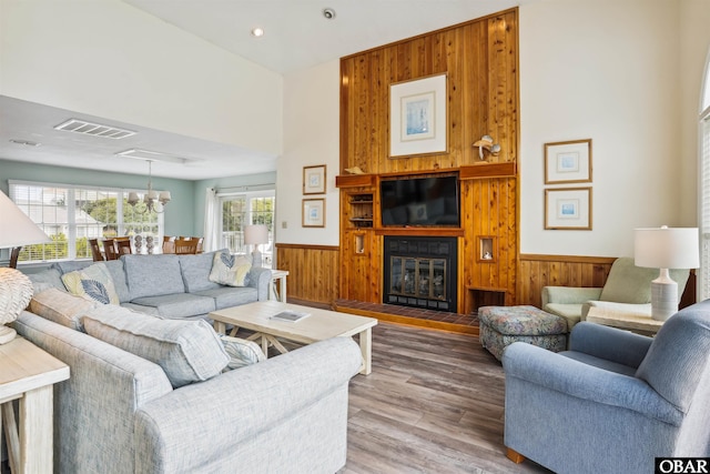 135 Ships Watch Dr Lot 32, Duck, NC 27949 - living room featuring wainscoting, wooden walls, a chandelier, light wood finished floors, and a large fireplace