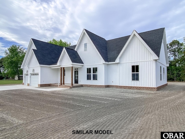 214 Augusta Dr Unit Lot69, Grandy, NC 27939 - modern farmhouse style home featuring a shingled roof, driveway, board and batten siding, and a garage