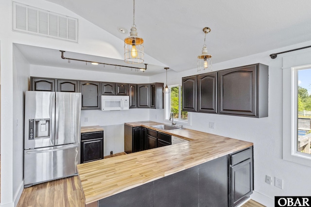 113 B And B Ln, Coinjock, NC 27923 - kitchen with stainless steel fridge, white microwave, butcher block counters, vaulted ceiling, and healthy amount of natural light