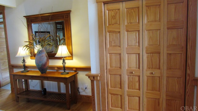 corridor featuring a wainscoted wall and wood finished floors