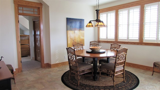 dining space featuring stone finish flooring and baseboards