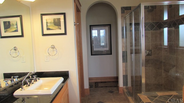 full bath featuring a shower stall, baseboards, tile patterned flooring, and vanity