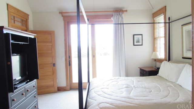 bedroom featuring vaulted ceiling and light colored carpet