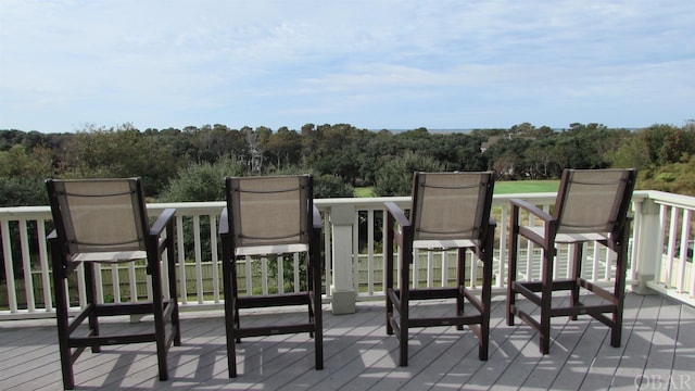 wooden terrace featuring a view of trees