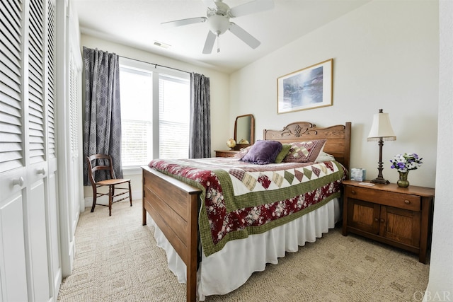 bedroom featuring light colored carpet, visible vents, and ceiling fan