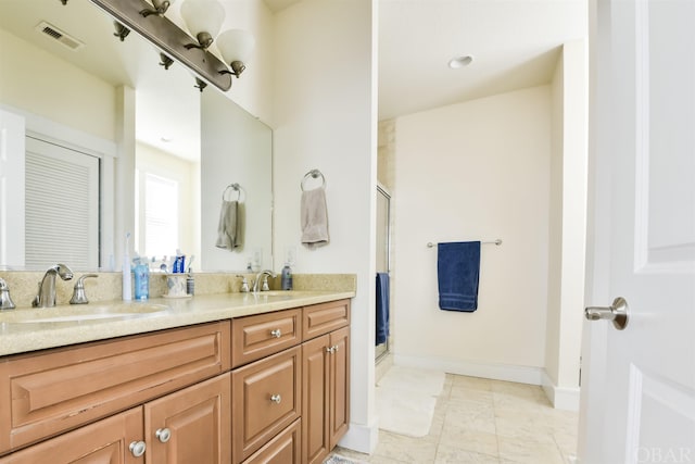 full bathroom featuring double vanity, a shower stall, visible vents, and a sink