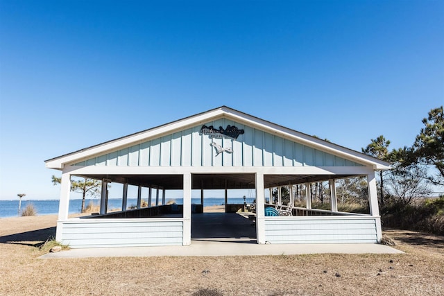 back of house with a water view, an exterior structure, and an outdoor structure