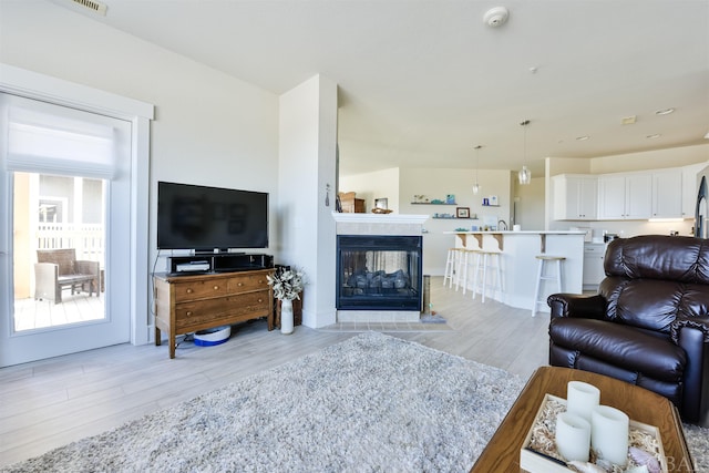 living room with light wood-style floors and a fireplace