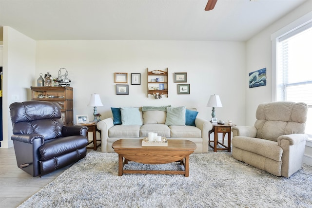 living area with light wood-style flooring and a ceiling fan