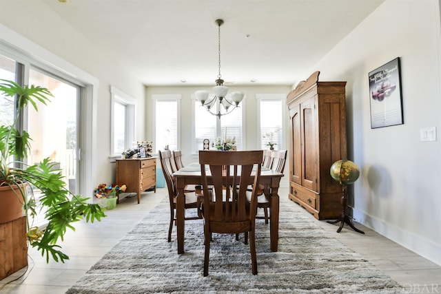 dining area with light wood-style floors, baseboards, and a notable chandelier