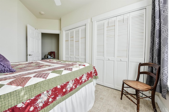 bedroom featuring a ceiling fan and two closets