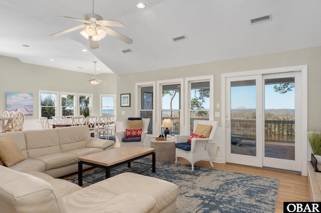 living area with vaulted ceiling, light wood finished floors, visible vents, and recessed lighting