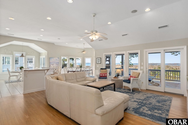 living room with light wood finished floors, visible vents, vaulted ceiling, and recessed lighting