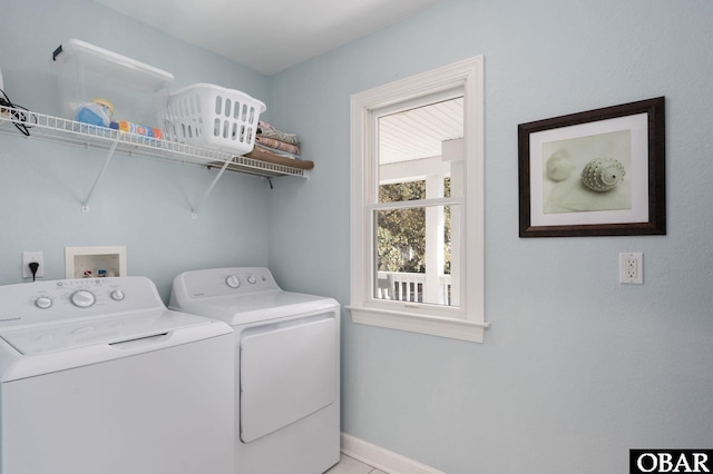 clothes washing area featuring laundry area, baseboards, and washer and clothes dryer