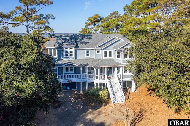 view of front facade with a porch, driveway, stairway, and an attached garage