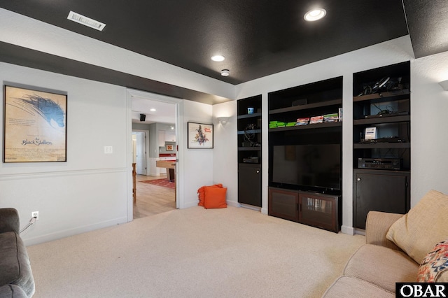 living room featuring recessed lighting, light colored carpet, visible vents, and baseboards