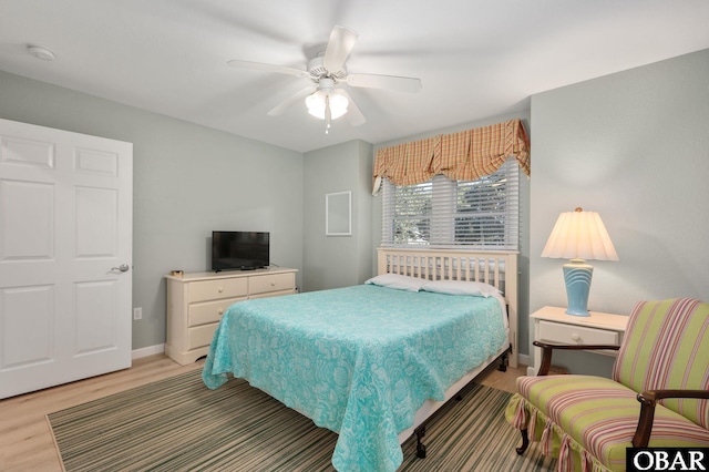 bedroom featuring light wood-type flooring, baseboards, and a ceiling fan