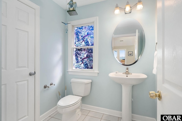 bathroom featuring a sink, tile patterned flooring, toilet, and baseboards