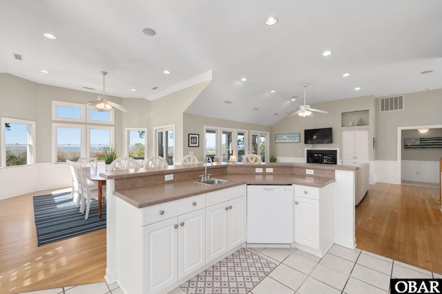 kitchen featuring white cabinetry, visible vents, open floor plan, dishwasher, and an island with sink