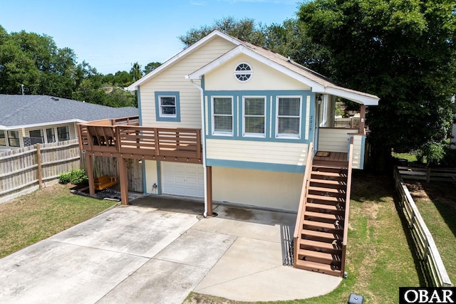 view of front facade featuring a garage, driveway, stairs, and a wooden deck