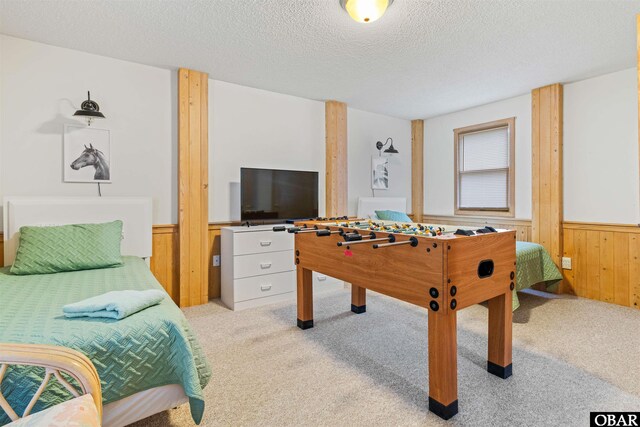 1039 Miller Ct Lot 526, Corolla, NC 27927 - bedroom with wood walls, wainscoting, light carpet, and a textured ceiling