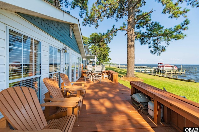 wooden terrace with a water view and a yard