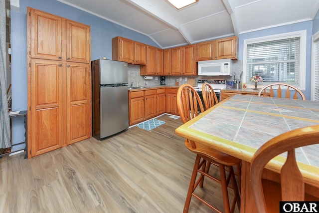 156 Longbeach Dr Unit Lot3, Hertford, NC 27944 - kitchen with white appliances, light wood-style floors, vaulted ceiling, backsplash, and brown cabinets
