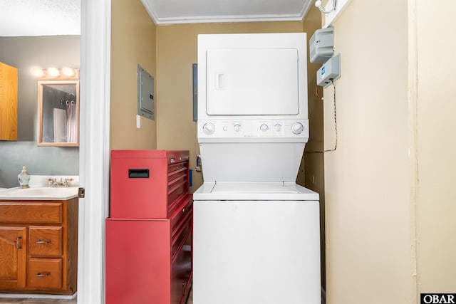 washroom with a sink, electric panel, and stacked washer / dryer