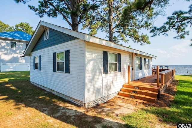 view of front of property featuring a deck with water view and a front yard