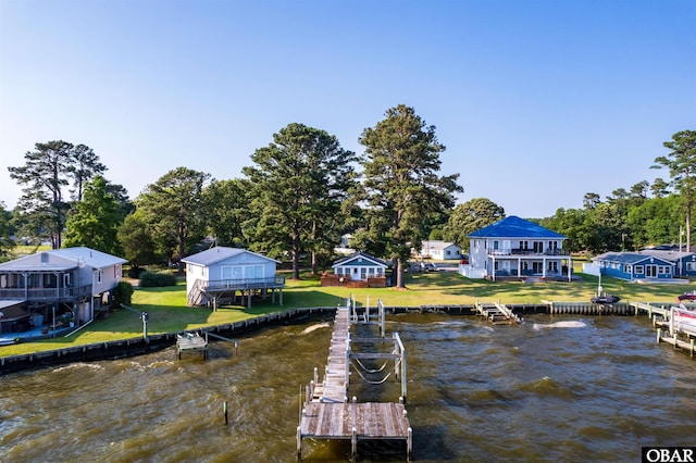 view of dock with a water view and a lawn