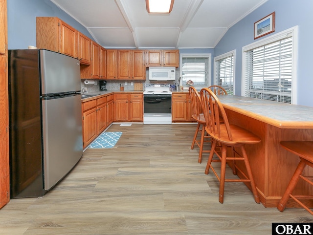 156 Longbeach Dr Unit Lot3, Hertford, NC 27944 - kitchen featuring freestanding refrigerator, electric range oven, white microwave, light wood-style floors, and lofted ceiling