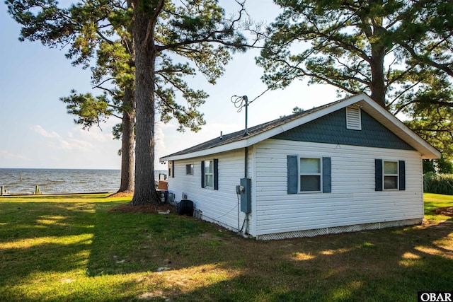 view of side of property with a water view and a yard