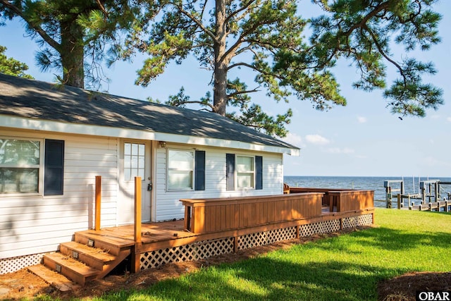 exterior space featuring a water view, a yard, and a boat dock