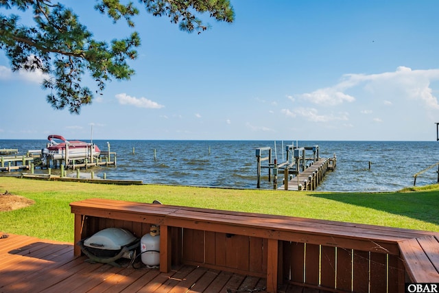 dock area with a water view, boat lift, and a lawn