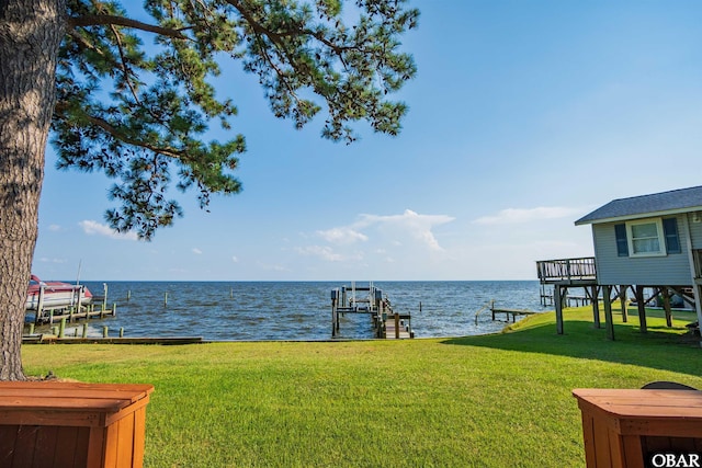 view of yard with a dock, a water view, and boat lift