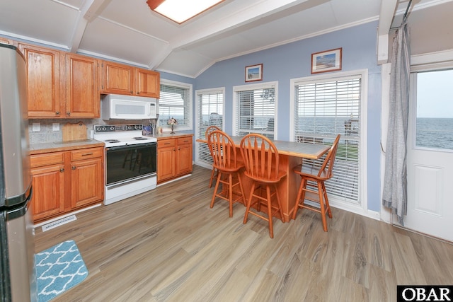 156 Longbeach Dr Unit Lot3, Hertford, NC 27944 - kitchen featuring white appliances, vaulted ceiling, light wood-type flooring, backsplash, and a breakfast bar