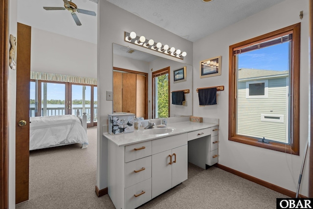 bathroom featuring a water view, baseboards, ensuite bathroom, and plenty of natural light
