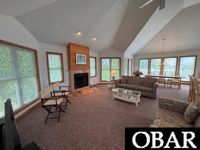 114 Poteskeet Dr Lot 66, Kitty Hawk, NC 27949 - living room featuring lofted ceiling, carpet floors, healthy amount of natural light, a fireplace, and a chandelier