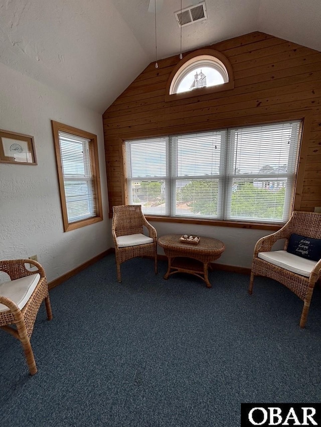 114 Poteskeet Dr Lot 66, Kitty Hawk, NC 27949 - living area with vaulted ceiling, carpet floors, and wooden walls